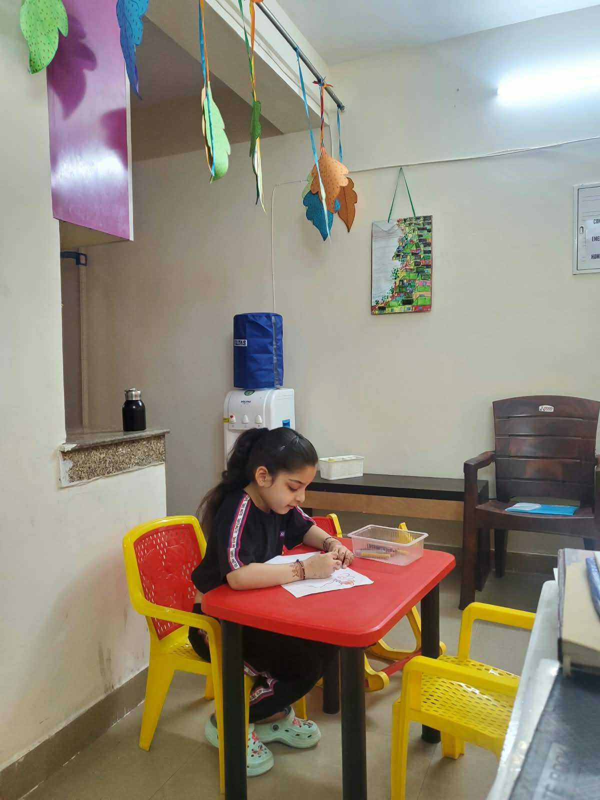 A child enjoying a drawing activity in the clinic play area